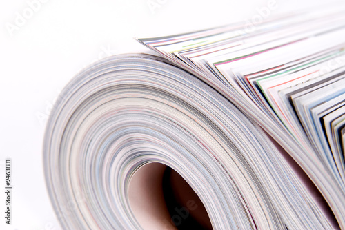 Three color magazines rolled on white background
