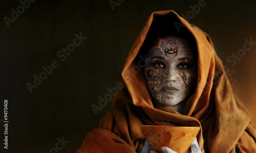 woman holding chalice with robe wrapped around the head
