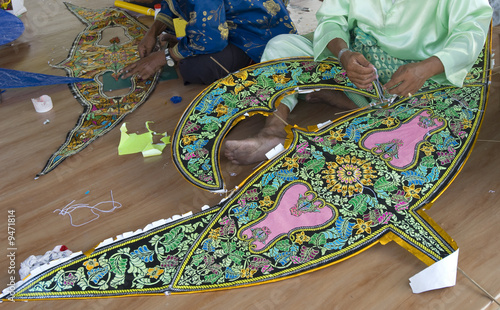 A Malay adult completing in the process of making kite.