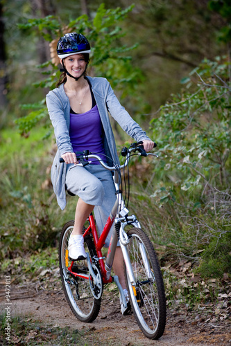 A young woman riding a bicycle in the woods