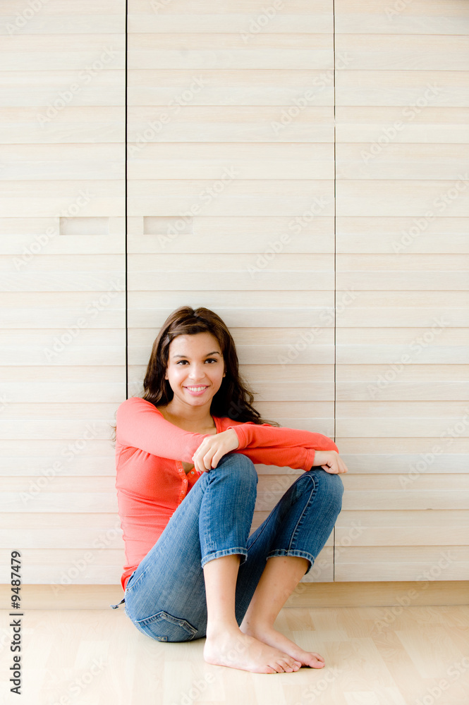 A young woman sitting on the floor at home A young woman sitting on the floor at home
