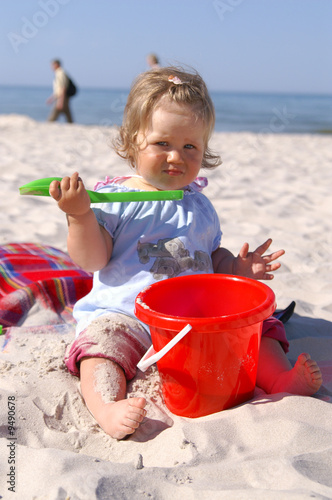 baby girl on the beach and blue sky