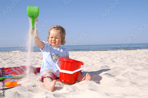 baby girl on the beach and blue sky