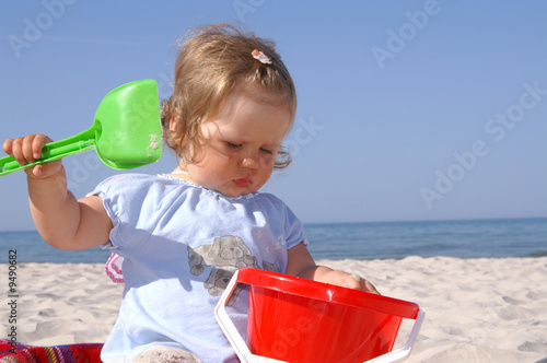baby girl on the beach and blue sky