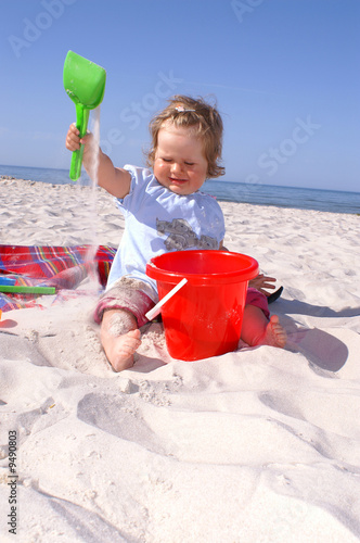 baby girl on the beach and blue sky