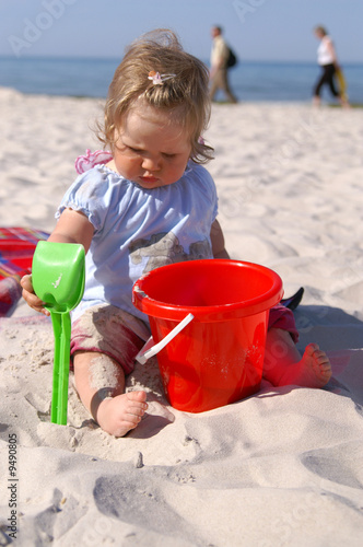 baby girl on the beach and blue sky