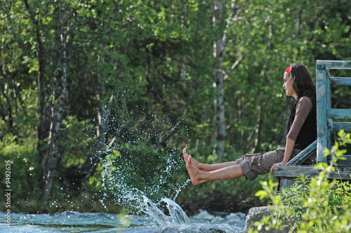 Freshness! Girl playing with river splashes.