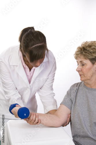 Physcial therapist helps a patient with rehab photo