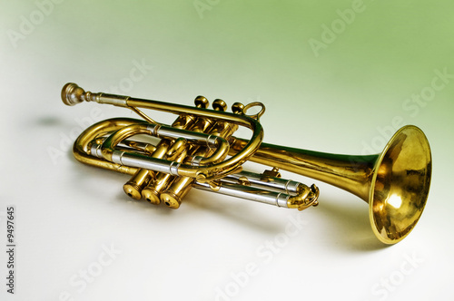 A trumpet containing green reflections in the brass