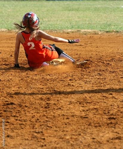 a fastpitch softball player sliding into second base