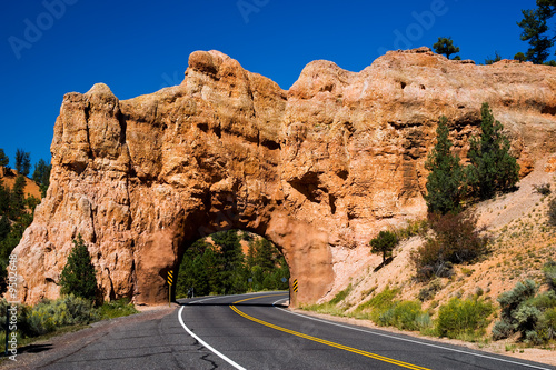 Road leading through a tunnel in a red mountain in Utah