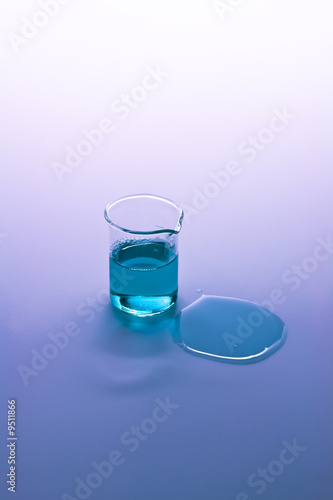 Test tube and spilled liquid with blue and purple background