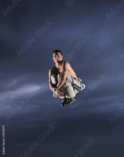 young man dancing and jumping on top of the building
