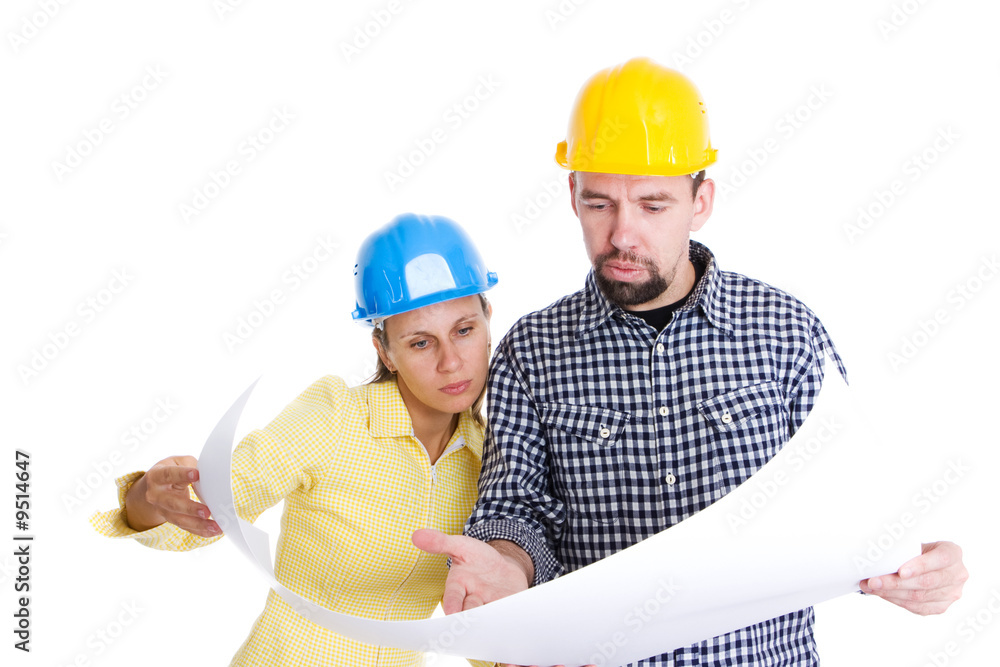 two architects wearing hardhats looking to the blueprint two architects wearing hardhats looking to the blueprint