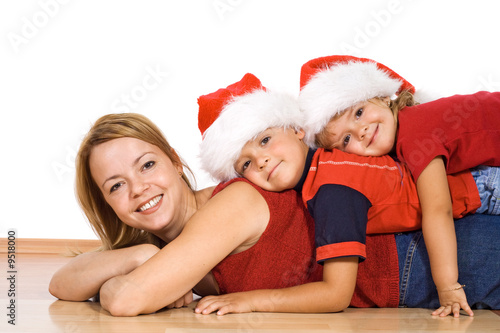Woman and her kids in a pile on the floor at christmas time