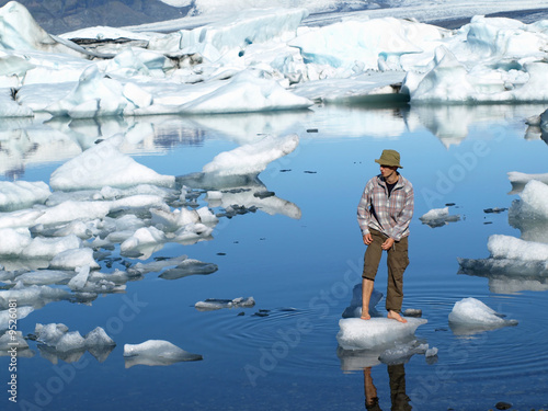Man, standing barefoot on ice in Jokulsarlon lagoon, Iceland