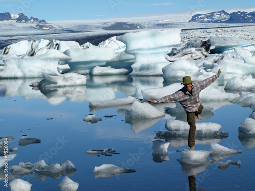 Man, standing barefoot on ice in Jokulsarlon lagoon, Iceland