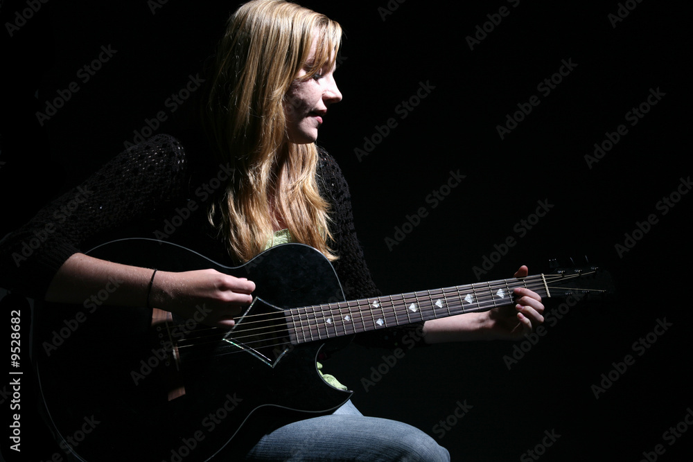 Fototapeta premium woman with long hair playing guitar and singing