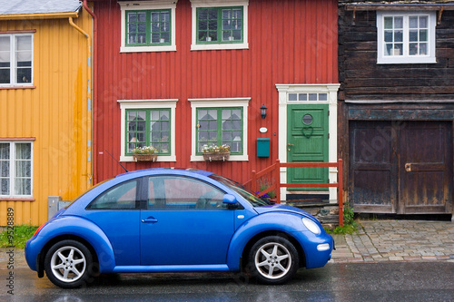 blue car on old style wooden colorful houses background © Oleg Kozlov