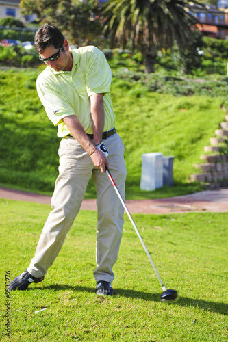 A golfer in action on a practice range, hitting the ball.