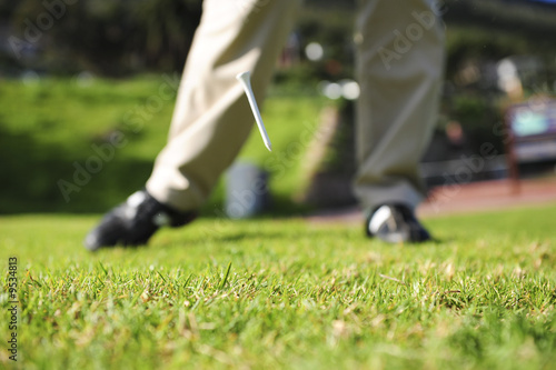 A golfer in action on a practice range, hitting the ball.