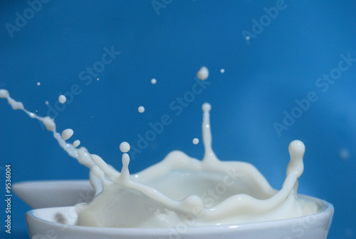 Extreme close-up of a milk splash with blue background