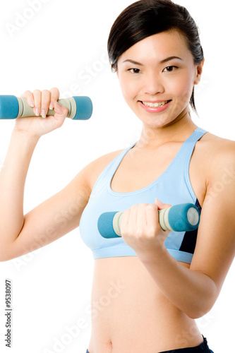 A young attractive Asian woman in sportswear with dumbbells