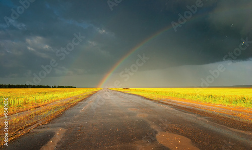 Landscape with country road and rainbow photo