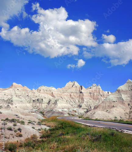 Road through the badlands in South Dakota with a cloudy sky.