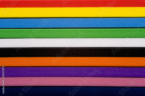 A stack of colorful foam, a mulit-colored  striped background