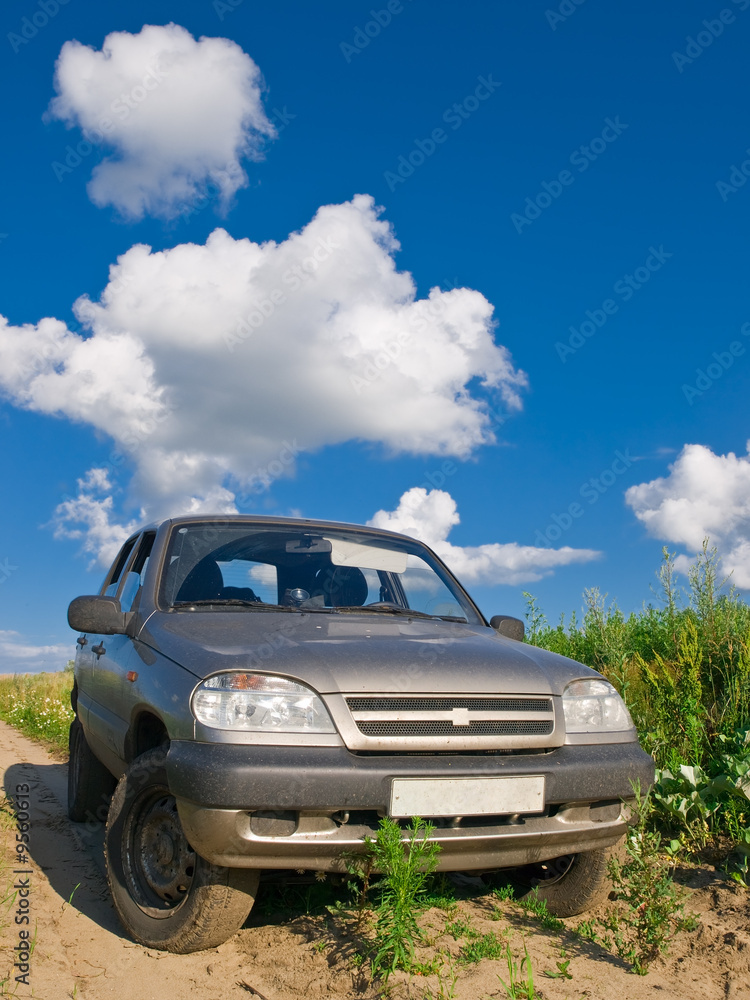 rural view with car over blue summer sky rural view with car over blue summer sky