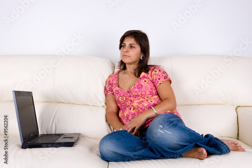 beautiful young woman with laptop on sofa