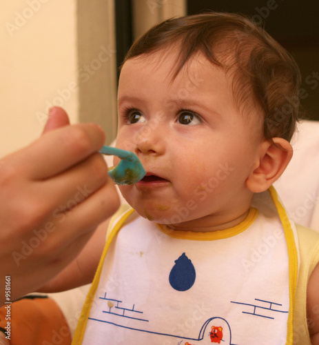 bambino mangia con cucchiaino photo