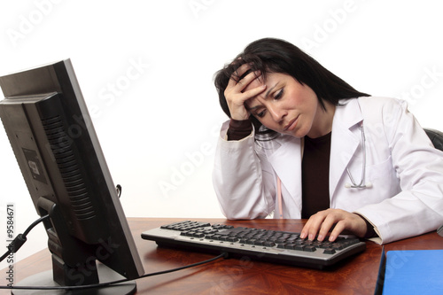Overworked tired or stressed doctor sitting at computer.