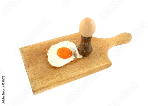 fried and fresh eggs on wooden board
