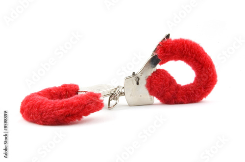 closed red handcuffs isolated on white background