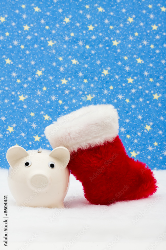Piggy bank and red stocking sitting on snow, Christmas savings Piggy bank and red stocking sitting on snow, Christmas savings