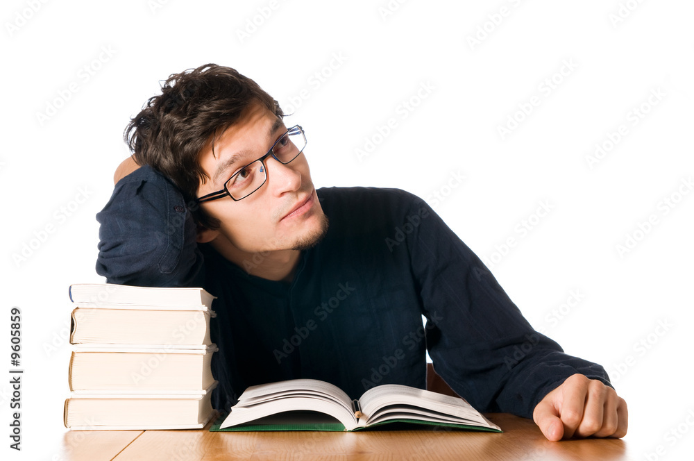 Pensive young man studying on a stack of books Pensive young man studying on a stack of books