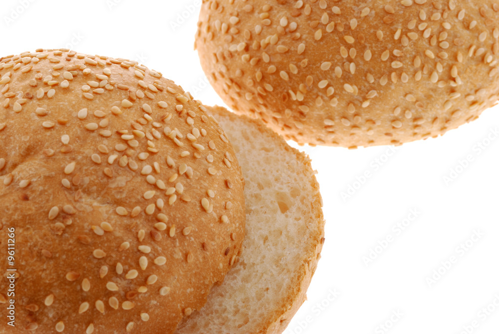 bun for sandwich cut . A bakery product strewed by grains bun for sandwich cut . A bakery product strewed by grains
