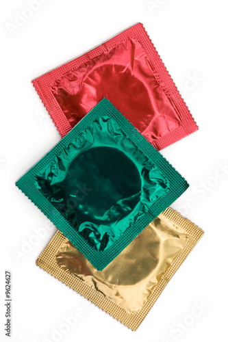 Coloured condoms in their wrappers on a white background