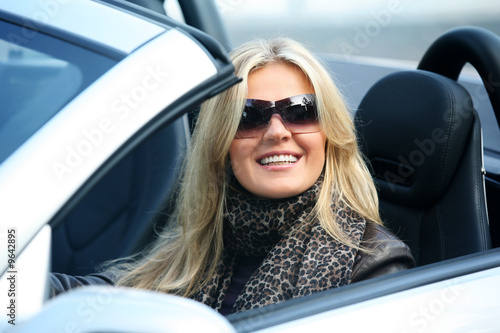 Blond girl in sunglasses driving convertable car © Galina Barskaya