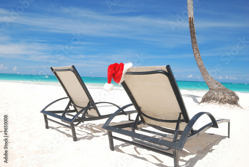 Santa s hat and chaise lounge on the beach
