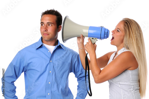 Young woman using megaphone to communicate to uninterested man photo