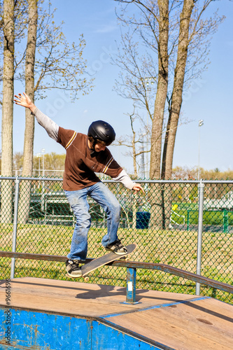 A teenage boy skateboarding at a park