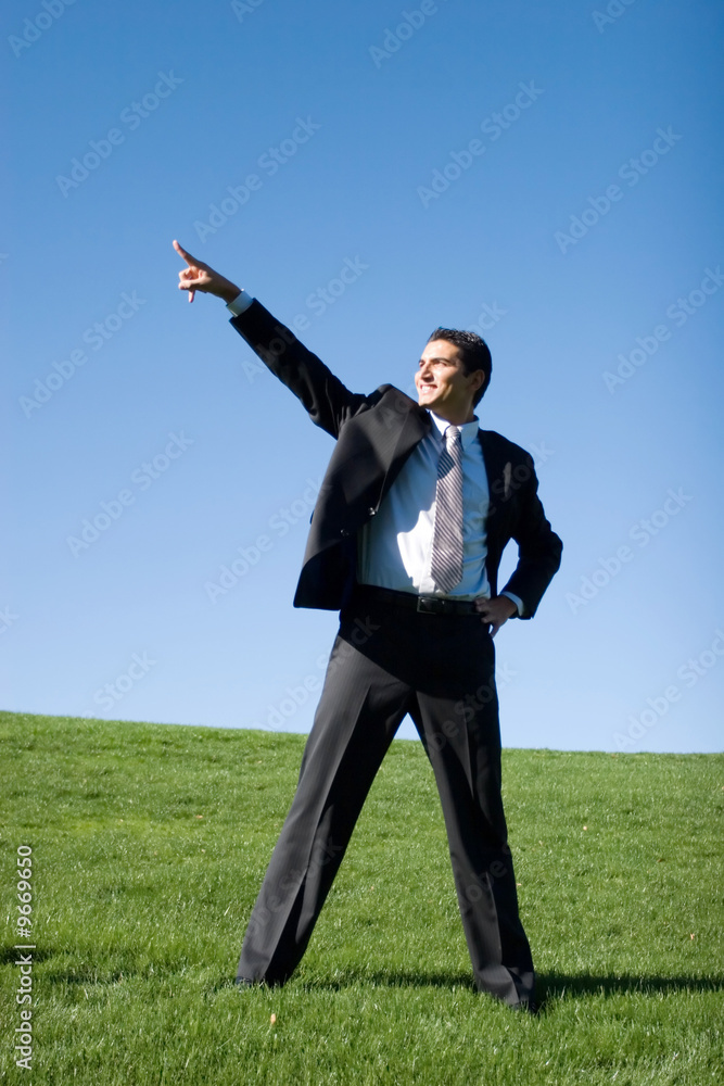 Confident businessman in dark suit pointing to the sky. Confident businessman in dark suit pointing to the sky.
