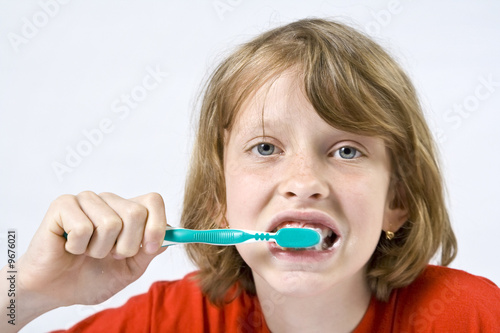 Little girl wearing colorful t-shirts brushing teeth