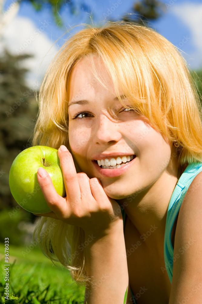 pretty woman eating green apple on the summer glade pretty woman eating green apple on the summer glade