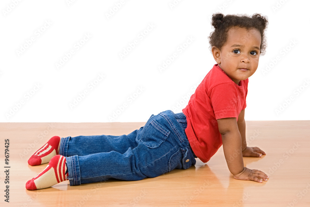Adorable african baby lying over wooden floor Adorable african baby lying over wooden floor