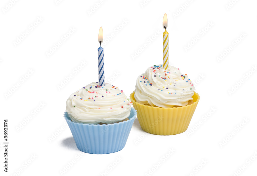 Two cupcakes with candle on white background Two cupcakes with candle on white background
