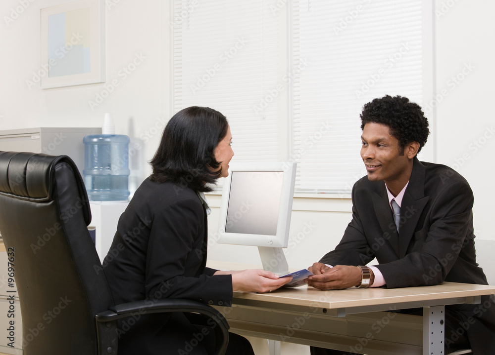 Woman explaining financial brochure to co-worker or customer Woman explaining financial brochure to co-worker or customer